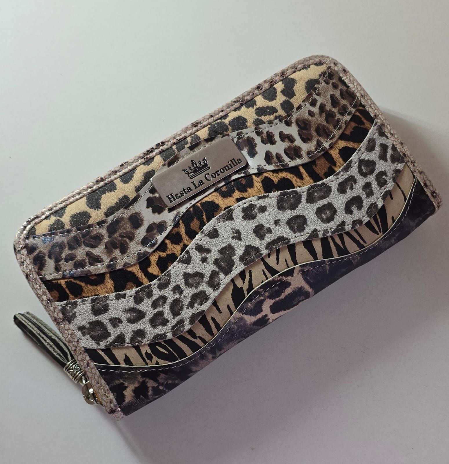 Una billetera rectangular con cierre de cremallera que presenta un patrón ondulado