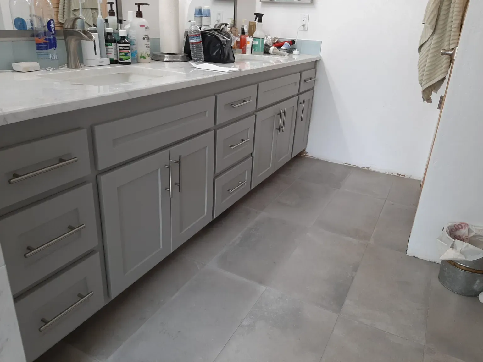 A bathroom with two sinks and a mop on the floor.