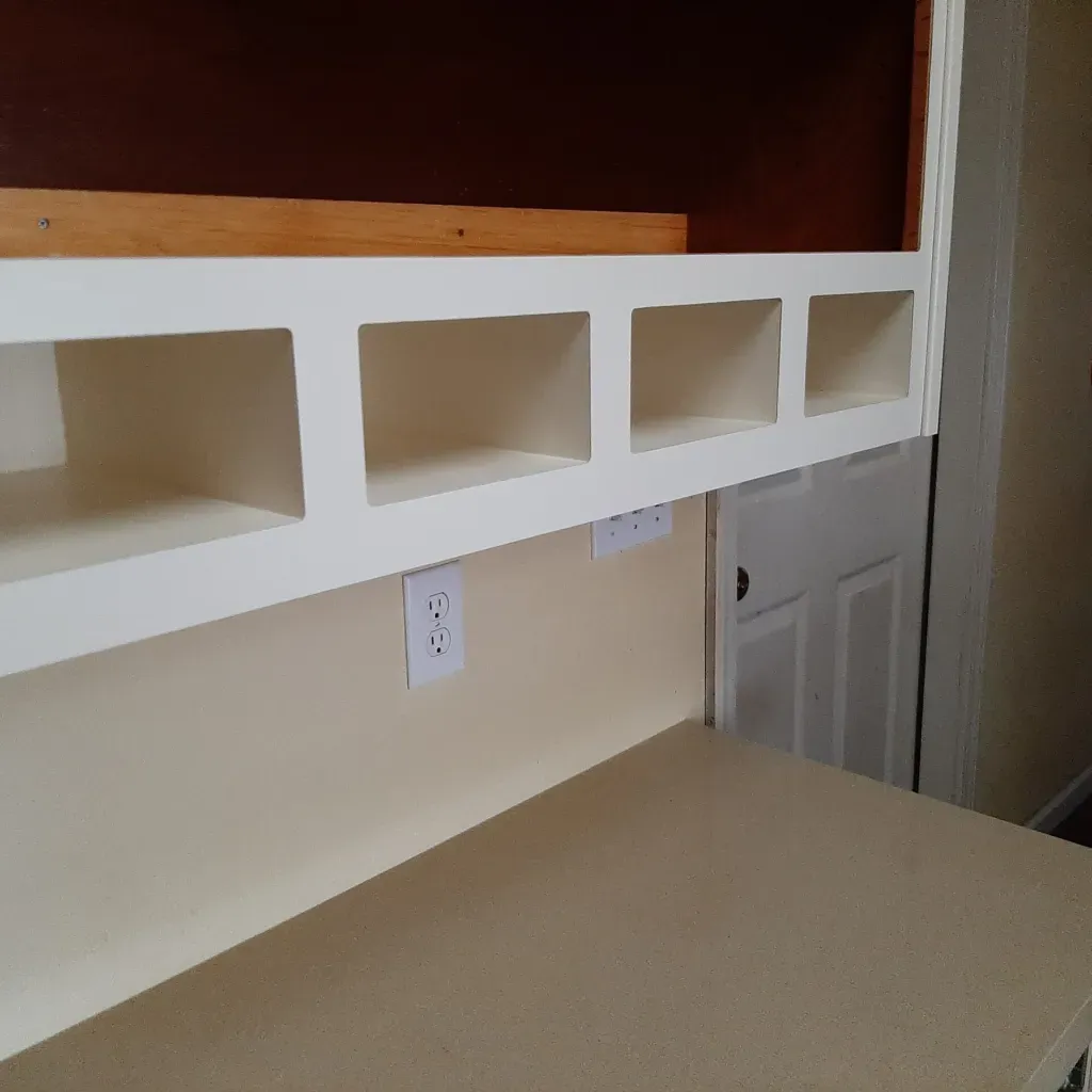 A white shelf with a few squares on it