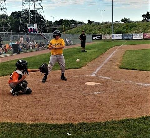 Baseball player sliding into base as another player attempts to catch the ball.