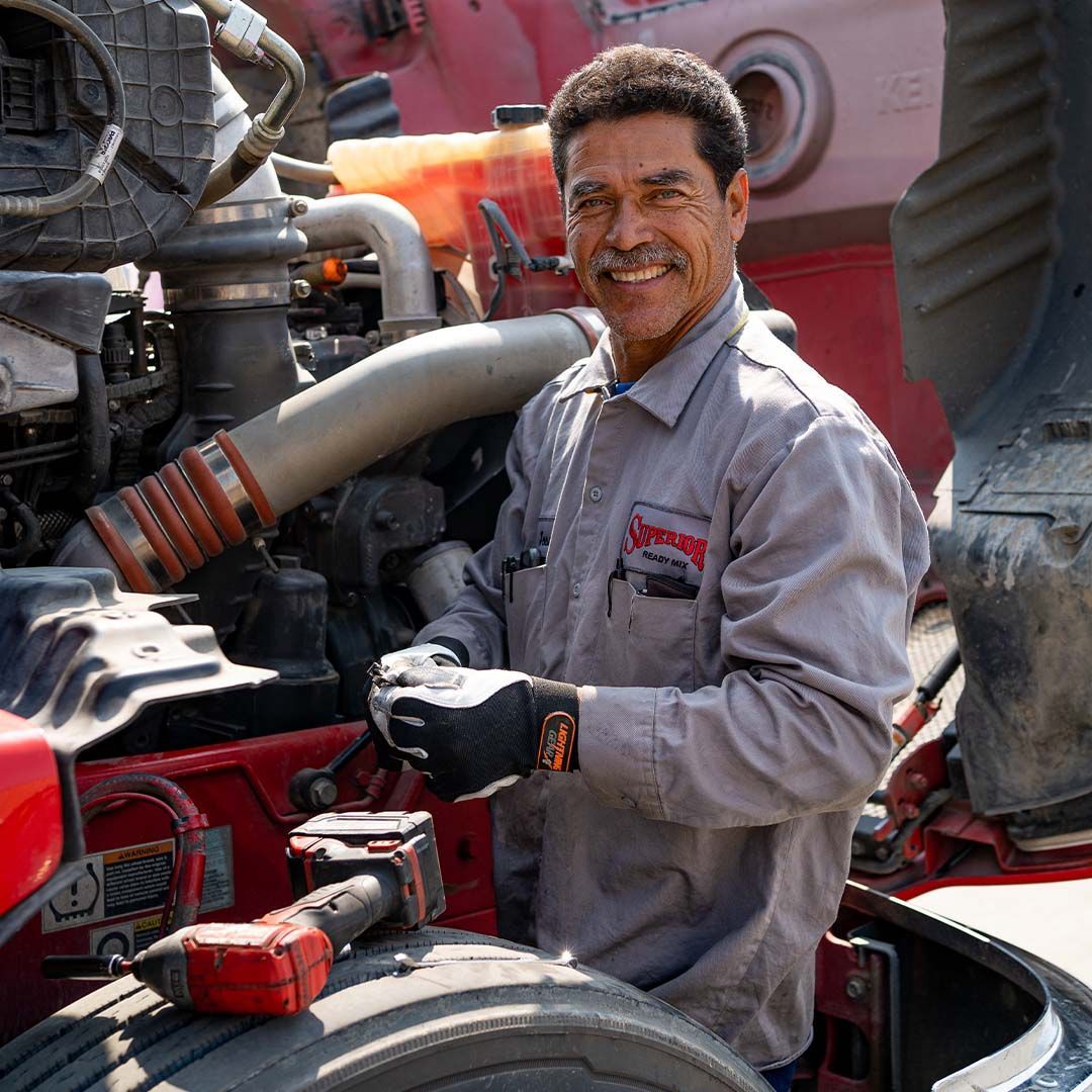 A man with a mustache is working on a truck engine