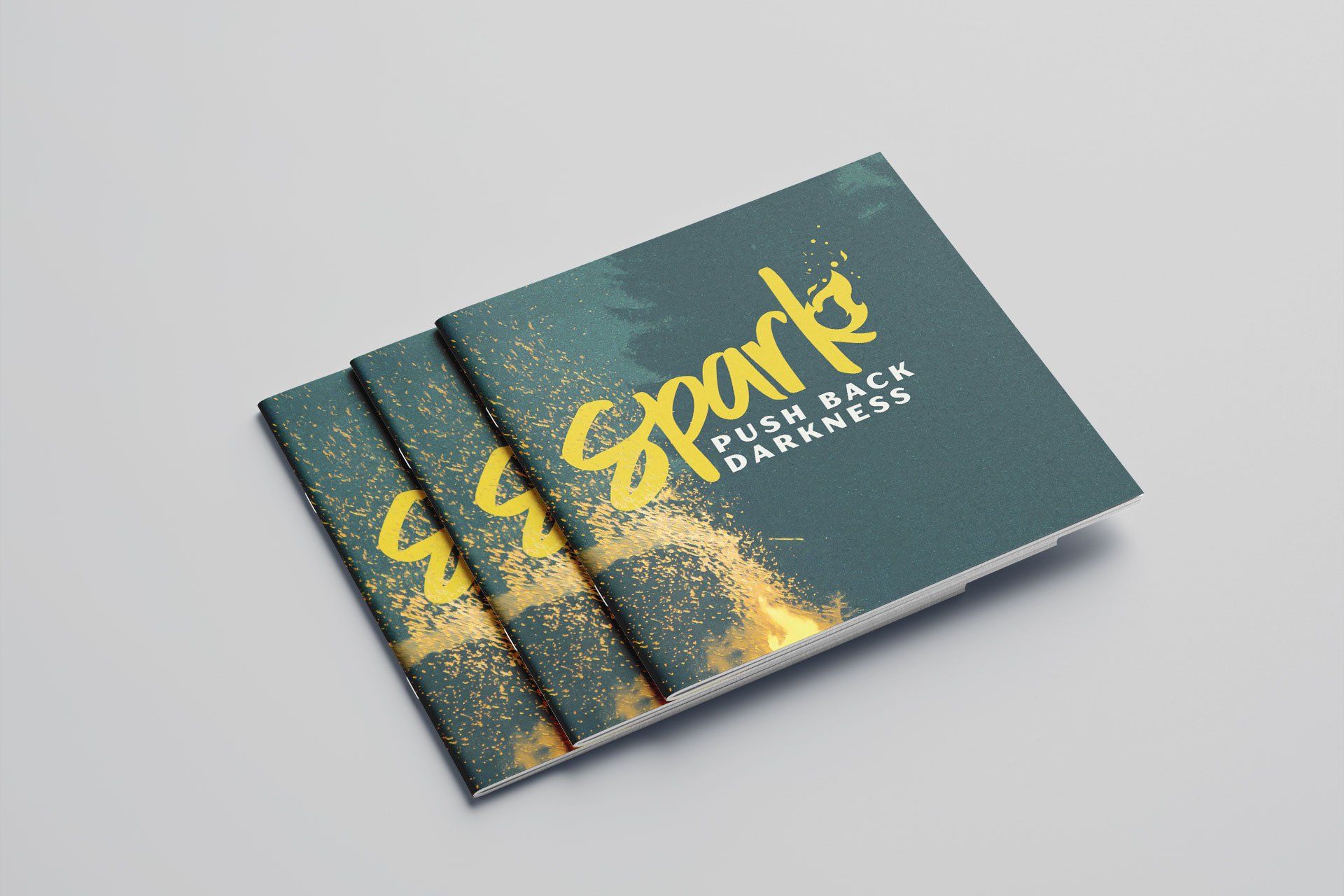 Three brochures are stacked on top of each other on a table.