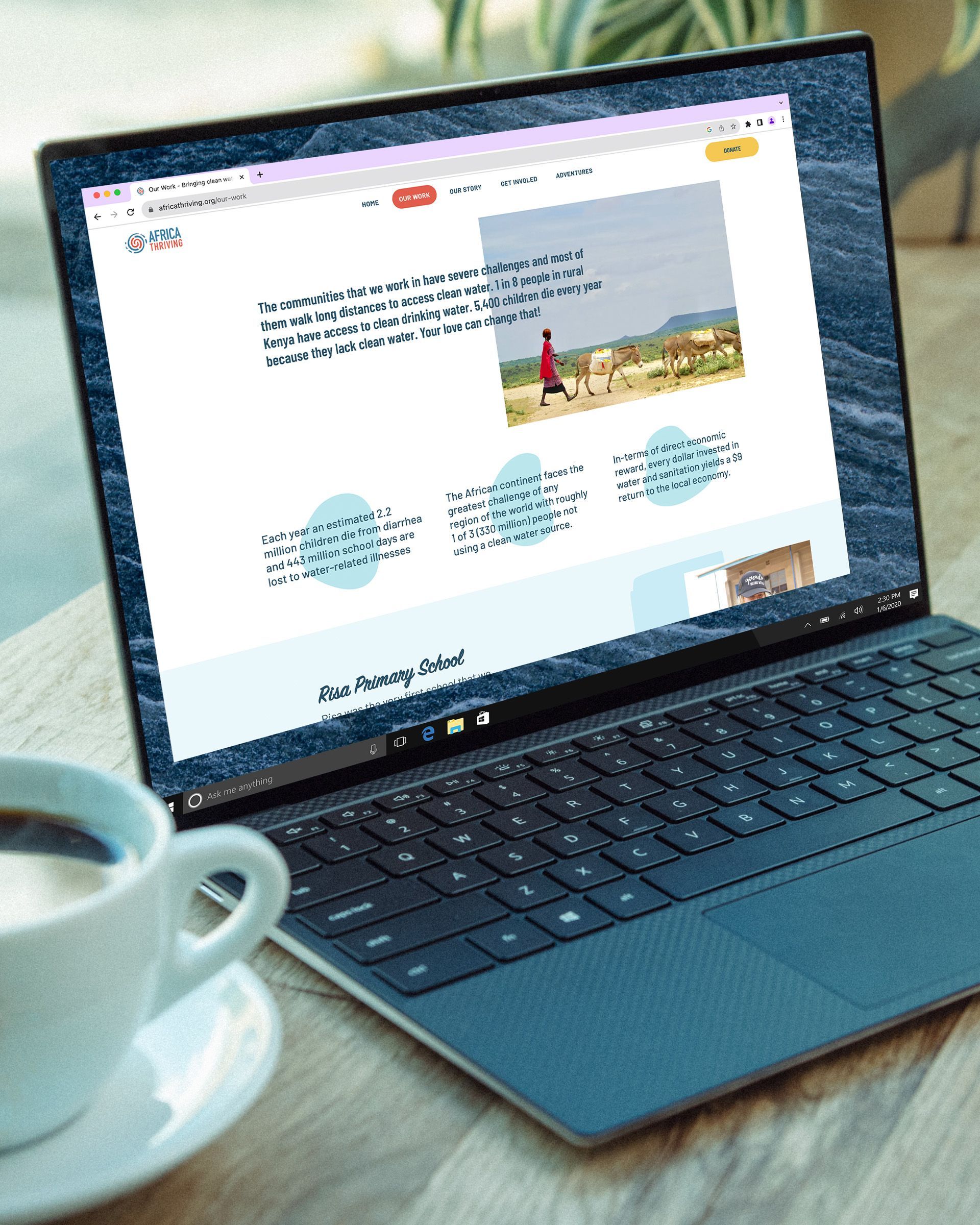 A laptop is open to a website next to a cup of coffee