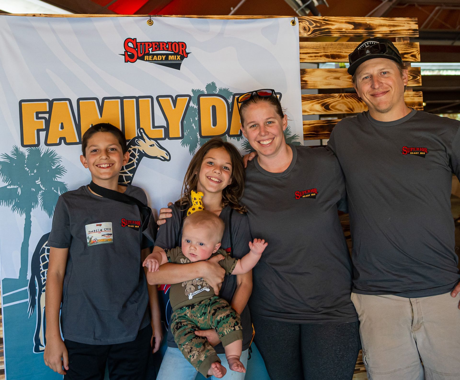 A family standing in front of a sign that says family day