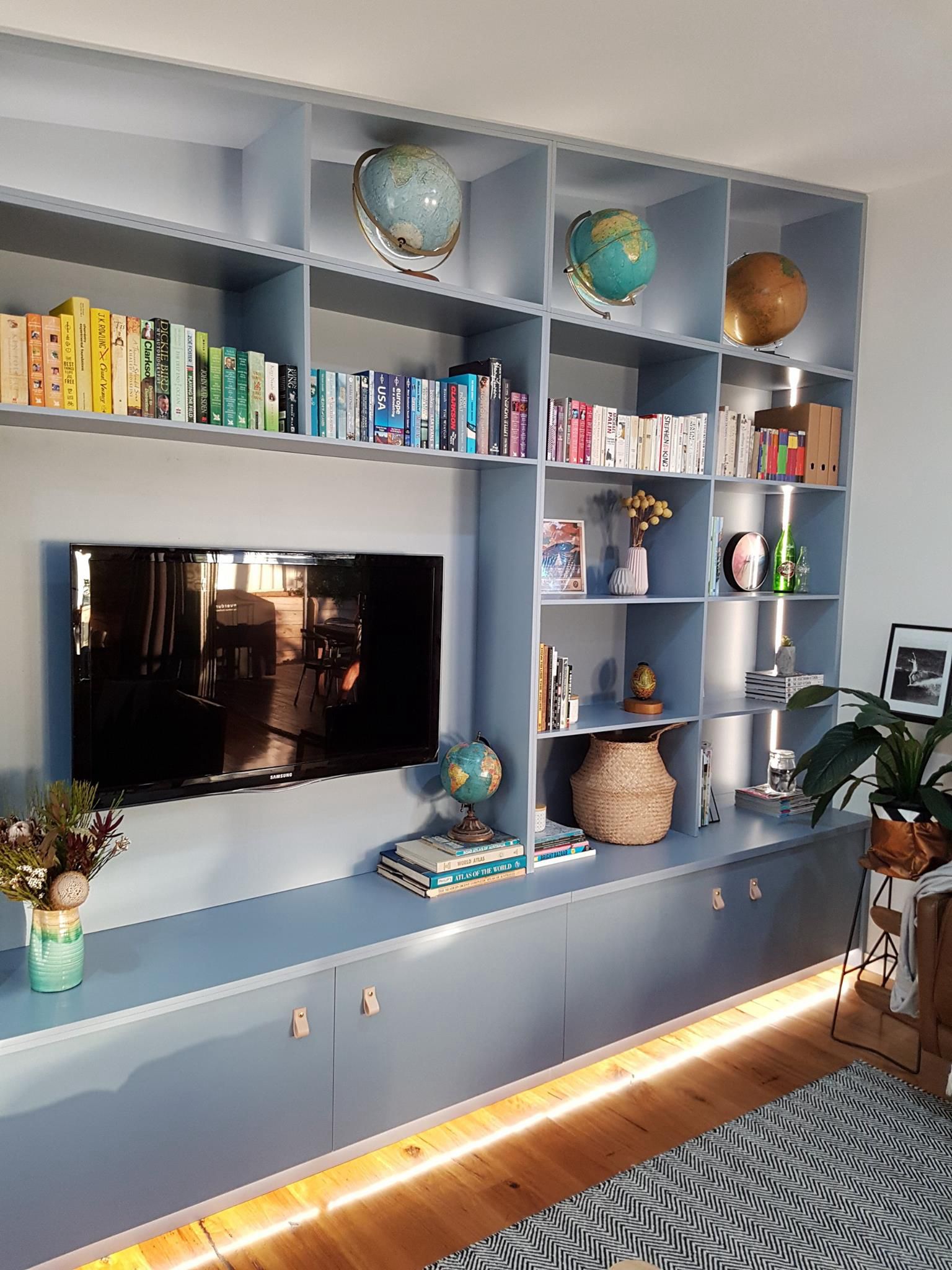 A living room filled with books, globe, and a flat screen tv. — Concept Kitchens In Port Macquarie, NSW