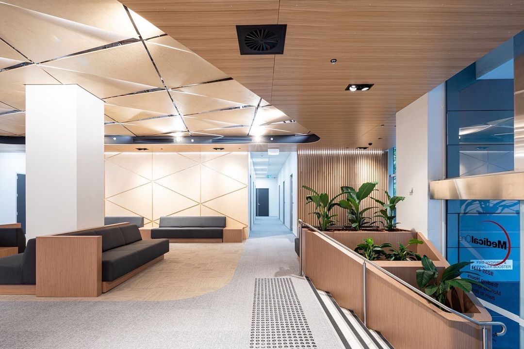 An Empty Office With a Lot of Tables and Chairs and a Brick Wall — Concept Kitchens In Port Macquarie, NSW