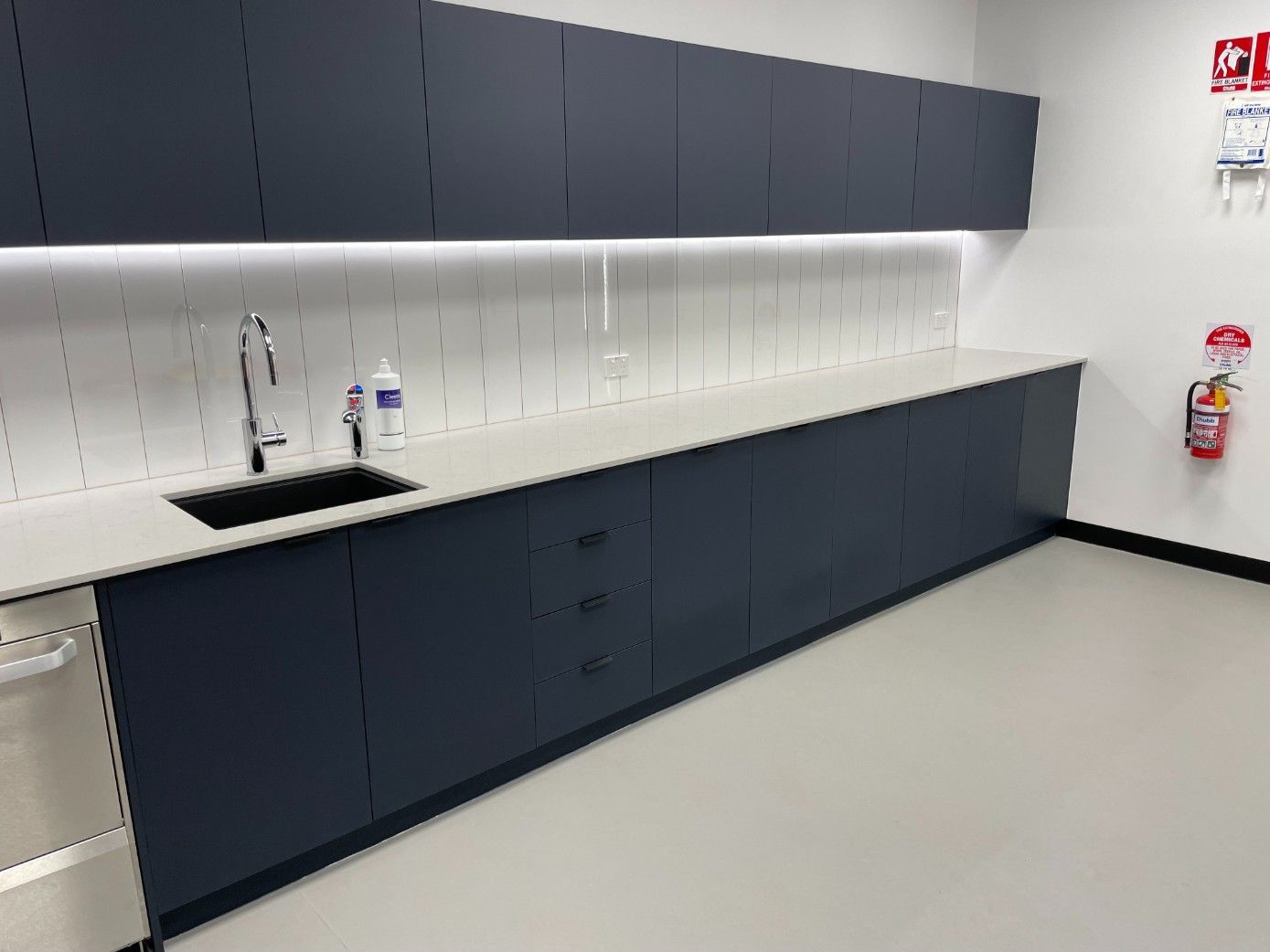A Kitchen With A Sink And A Fire Extinguisher On The Wall — Concept Kitchens In Port Macquarie, NSW