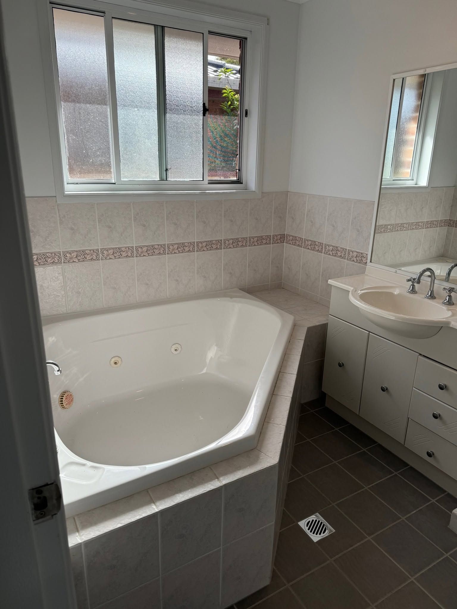 Bright Bathroom with Corner Bathtub, Sink Vanity, Mirror, Window — Mid Coast Tile Co in Wingham, NSW