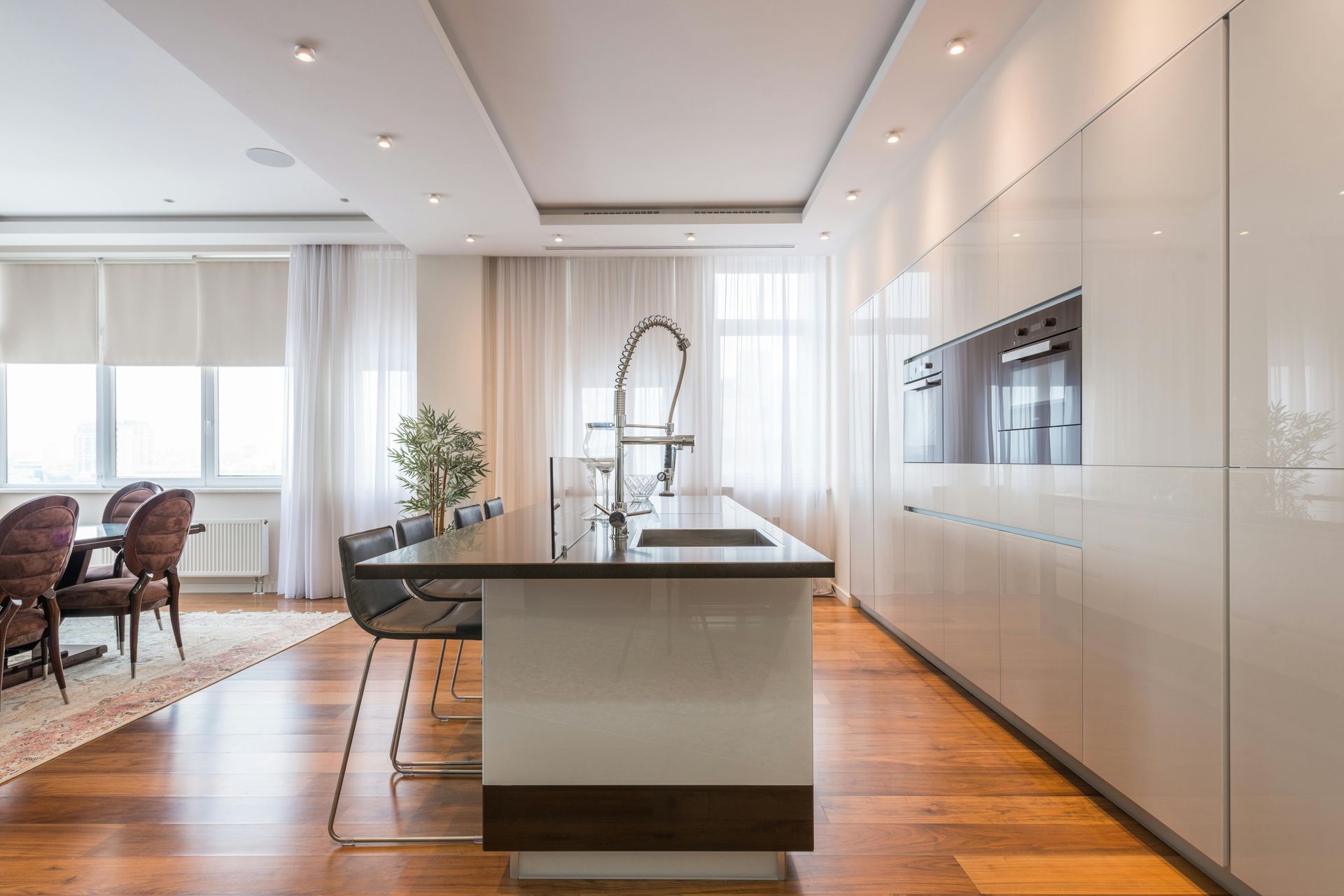 Modern Kitchen with A Large Island, White Cabinets, Wood Floors — Mid Coast Tile Co in Taree, NSW