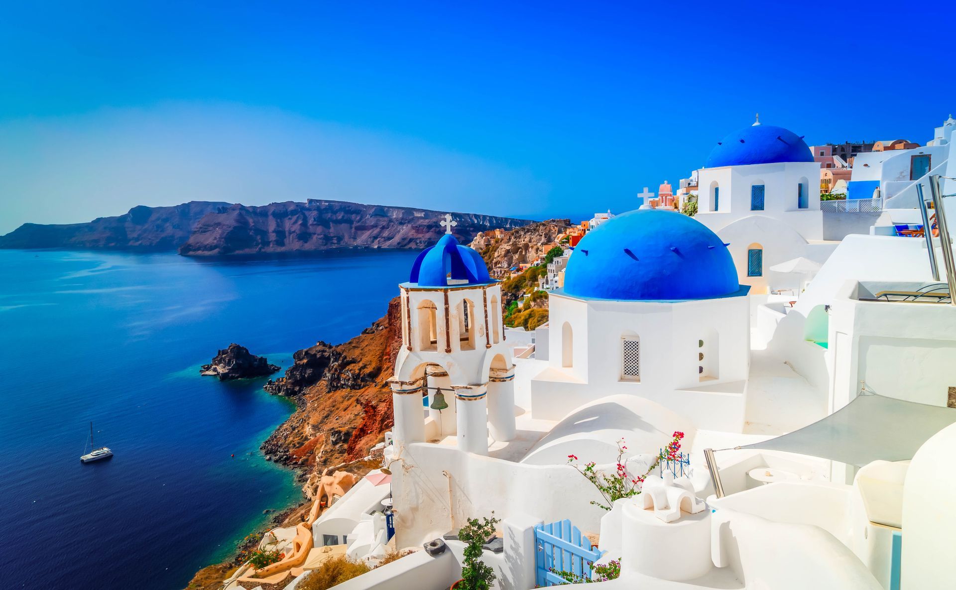 White buildings with blue domes overlooking the sea and cliffs in Santorini, Greece