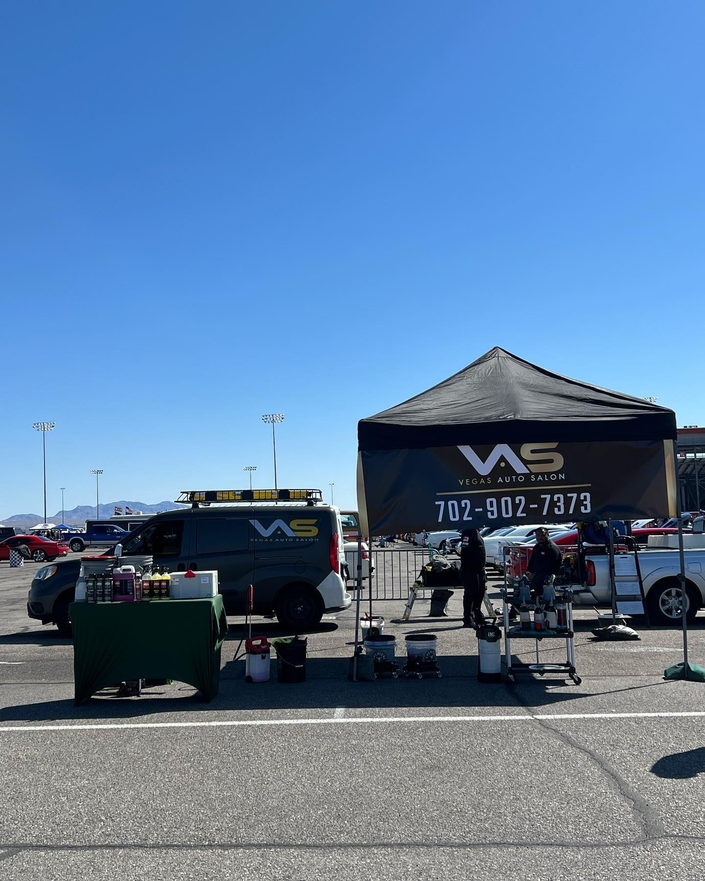 A van is parked in a parking lot next to a tent.