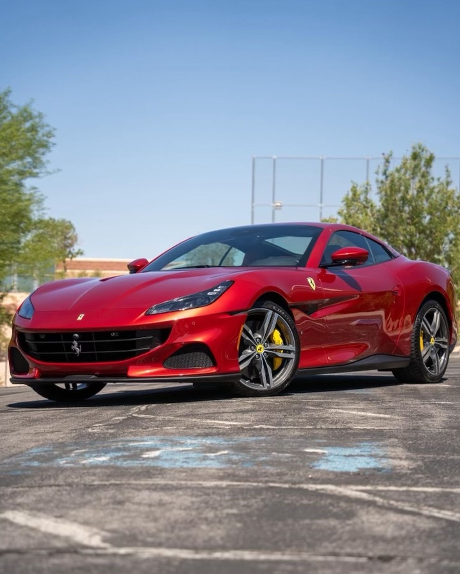 A red ferrari is parked in a parking lot.