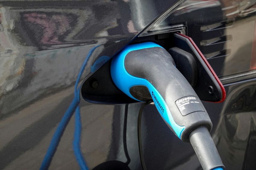 Electric vehicle charging plug connected to a car's charging port