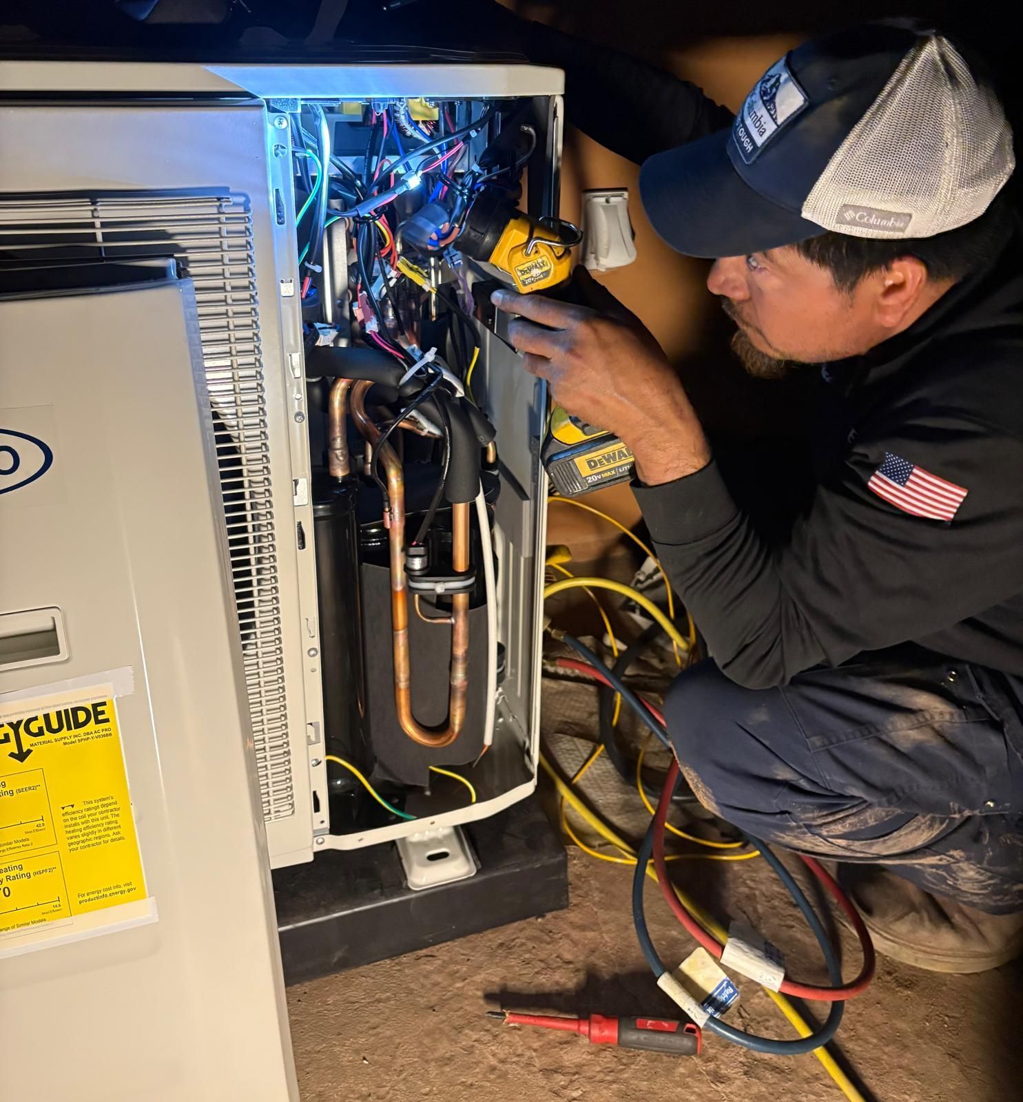 Electrician inspecting a circuit breaker panel with gloved hands in a utility room