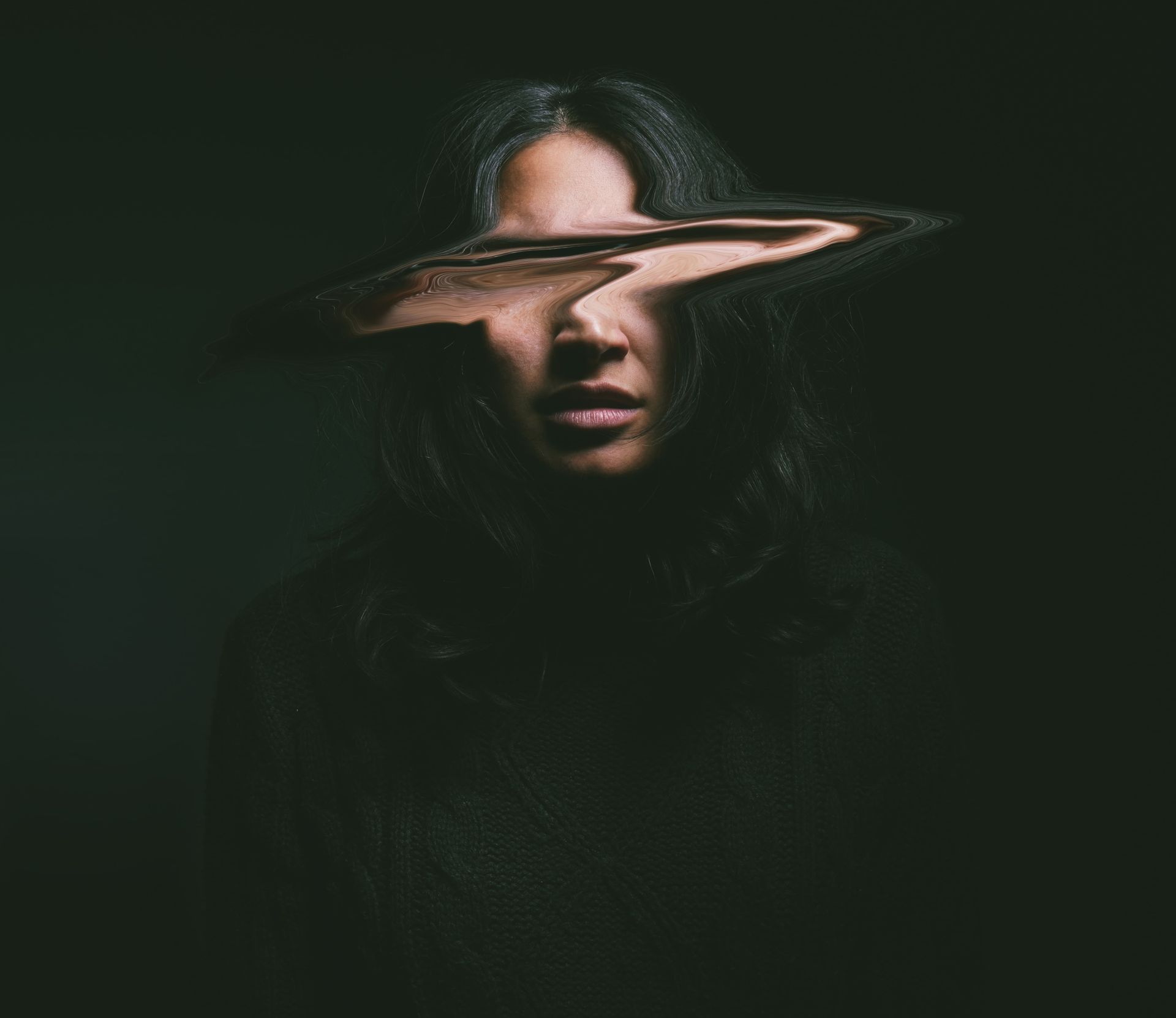 Uma mulher com o reflexo de seu rosto em um espelho.