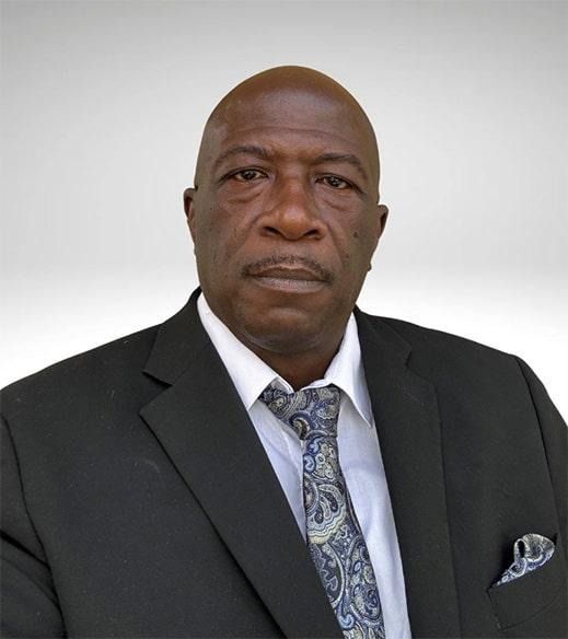 Man in a suit and tie, looking directly at the camera.
