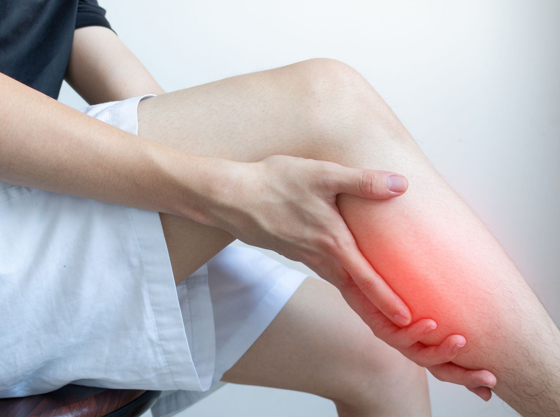 Person holding a painful knee with red glow highlighting the injury