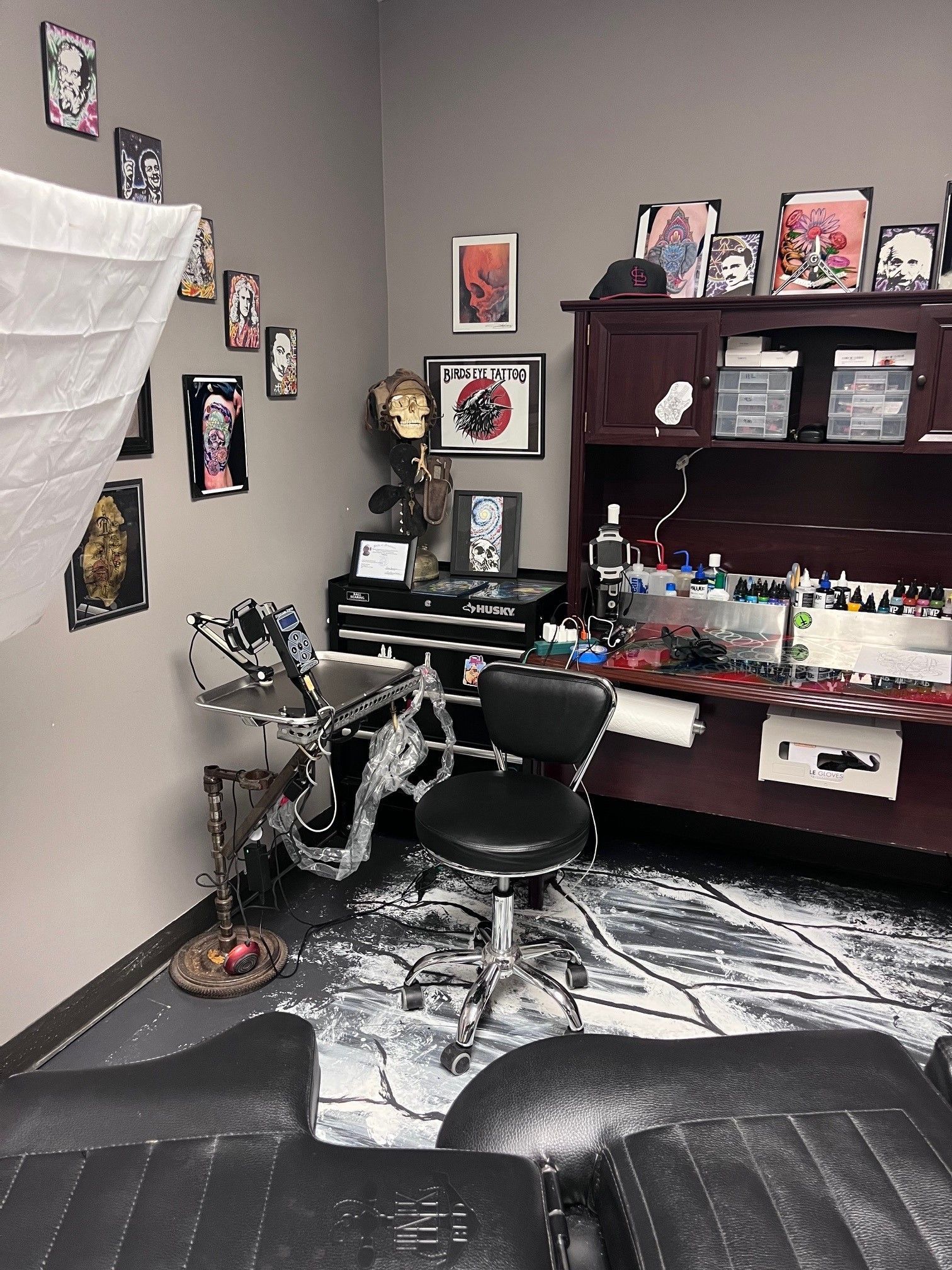 A room with a lot of pictures on the wall and a chair