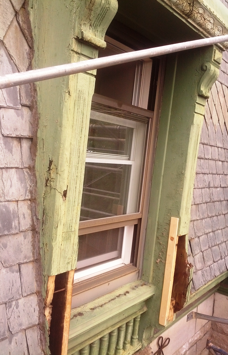 Une fenêtre sur le côté d'un bâtiment avec un cadre vert.