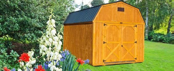 Orange wooden garden shed with double doors on a green lawn, surrounded by colorful flowers and trees