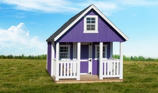 Small purple and white house with a porch, standing alone in a grassy field under a blue sky