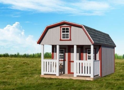 Small white and gray playhouse with red trim and porch in a grassy field under blue sky
