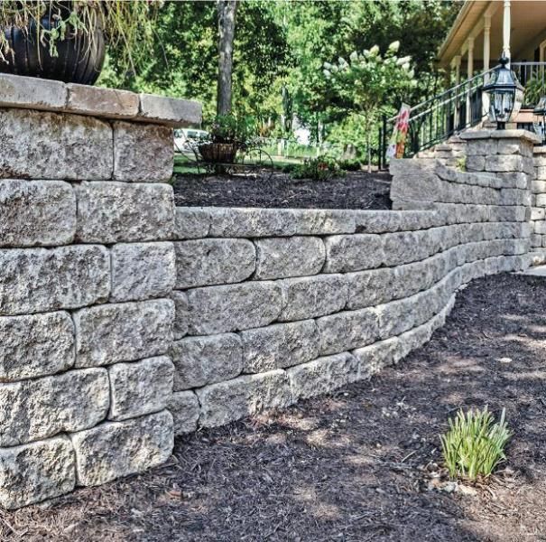 Curved stone retaining wall in a landscaped garden with steps and greenery