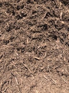 Close-up of brown wood chips and mulch covering the ground.