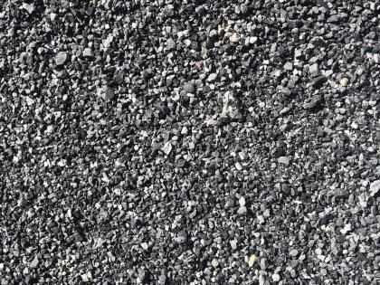 Close-up of dark gray gravel with scattered white and light stones