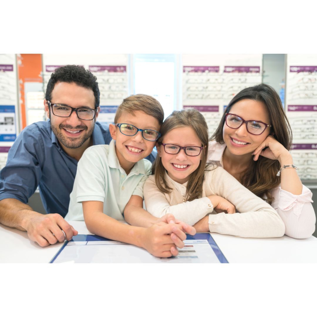 A family wearing glasses is sitting at a table.