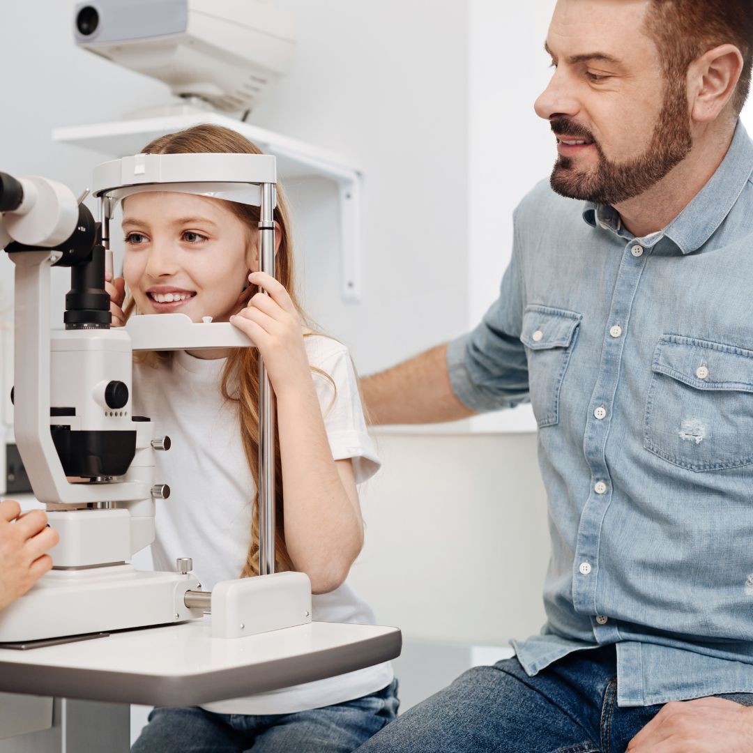 A little girl is getting her eyes examined by an ophthalmologist.
