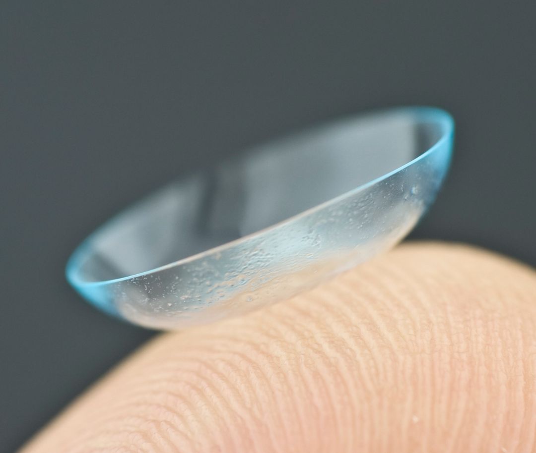 A close up of a contact lens on a finger