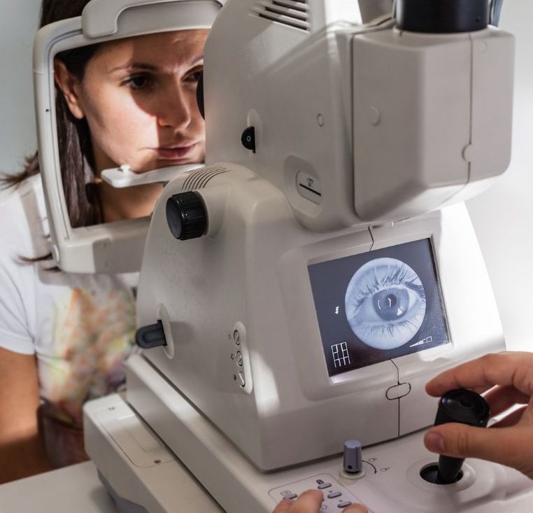 A woman is getting her eyes examined by an ophthalmologist