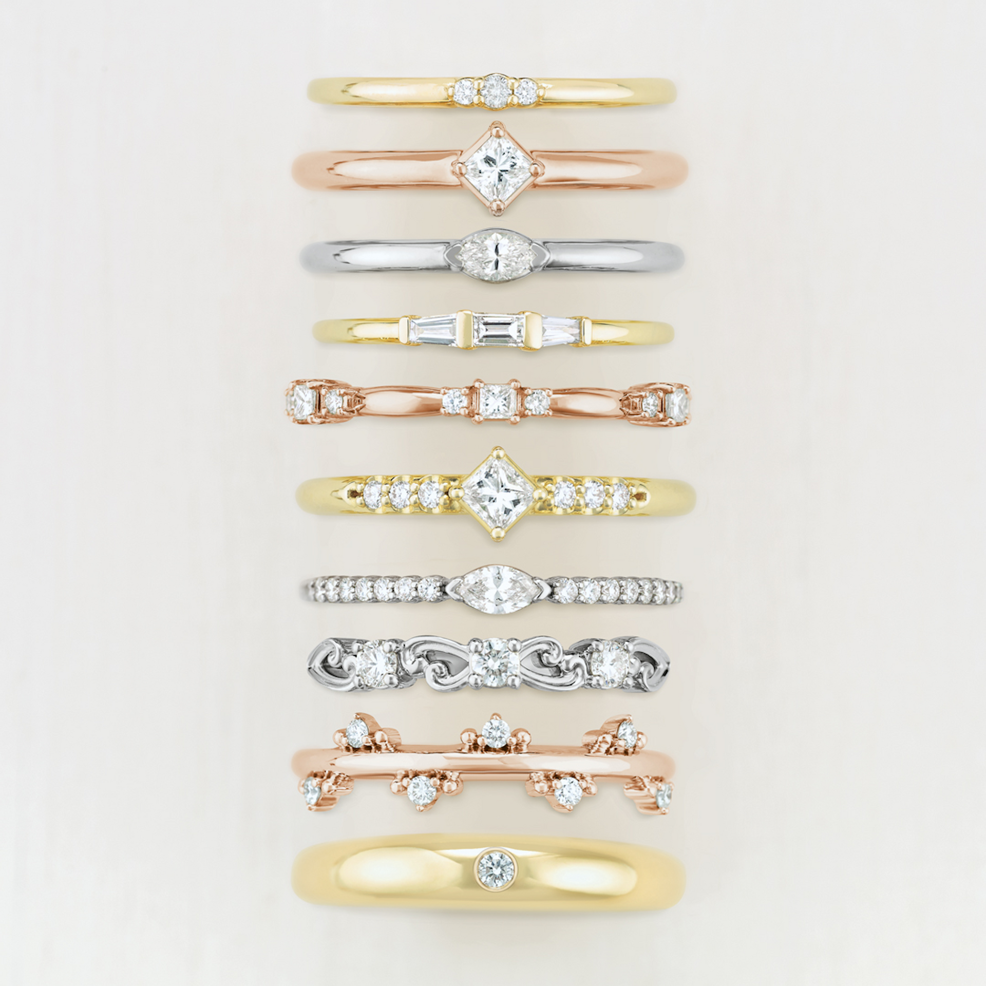 A row of rings are lined up in a row on a white surface.