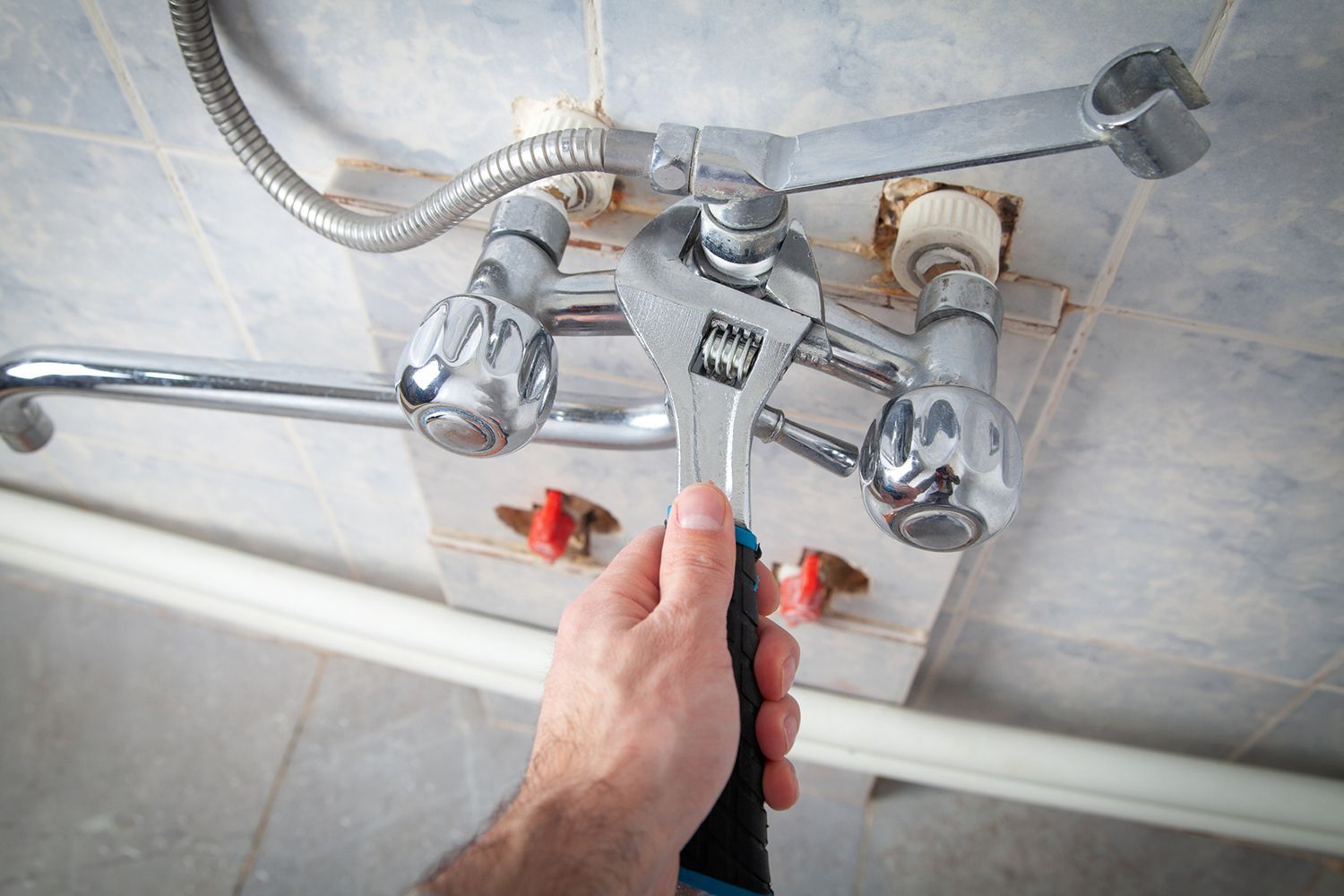 A person is fixing a faucet with a wrench. A person is fixing a faucet with a wrench.