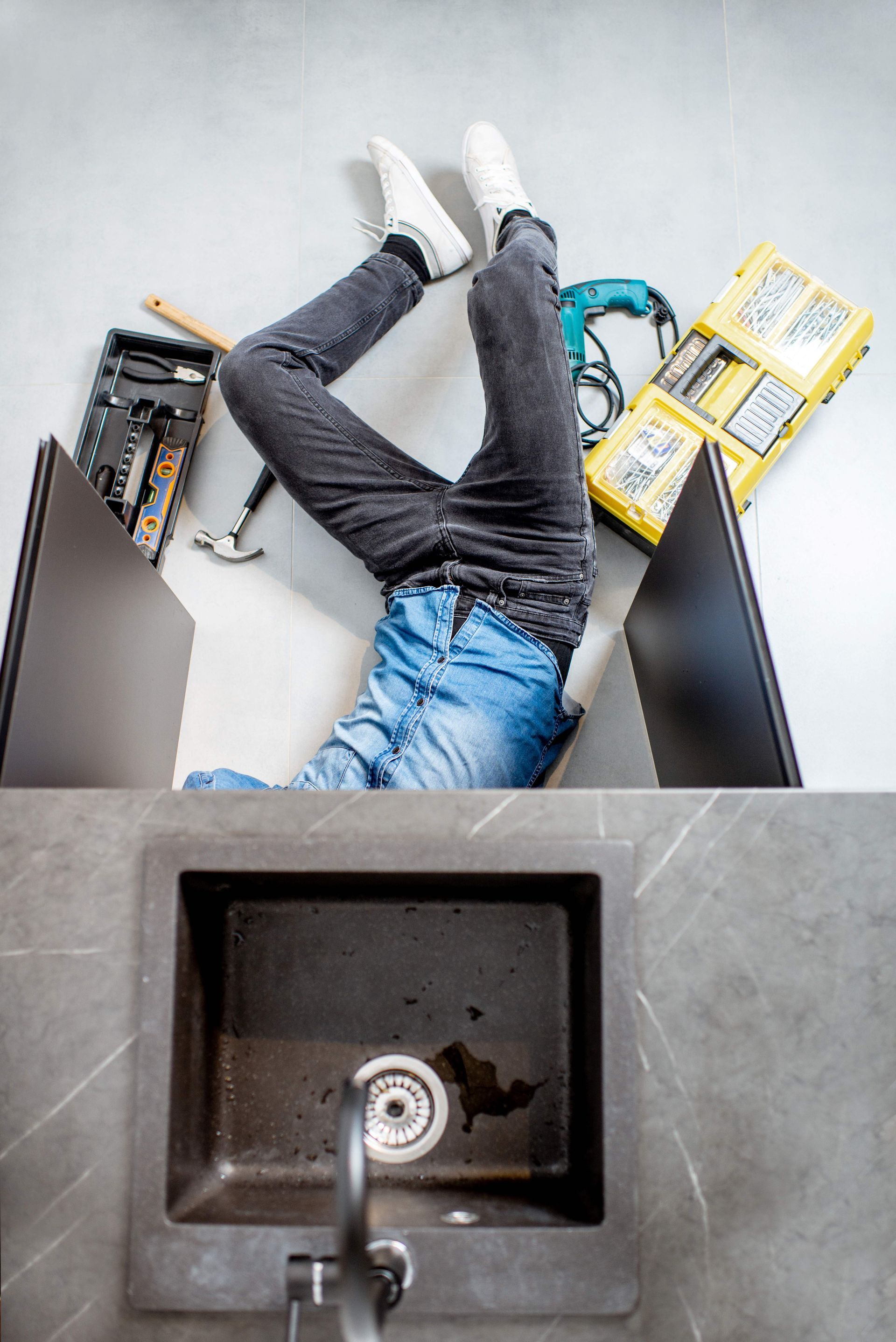 A plumber performs residential plumbing services, repairing a kitchen sink. A plumber performs residential plumbing services, repairing a kitchen sink.