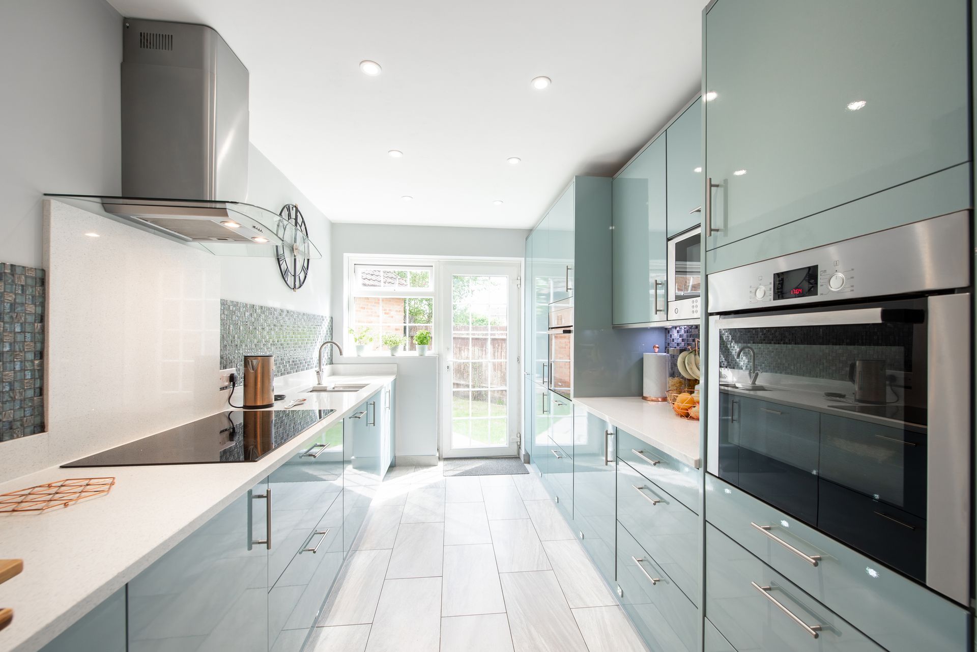 A kitchen with blue cabinets and stainless steel appliances. Modern blue kitchen.