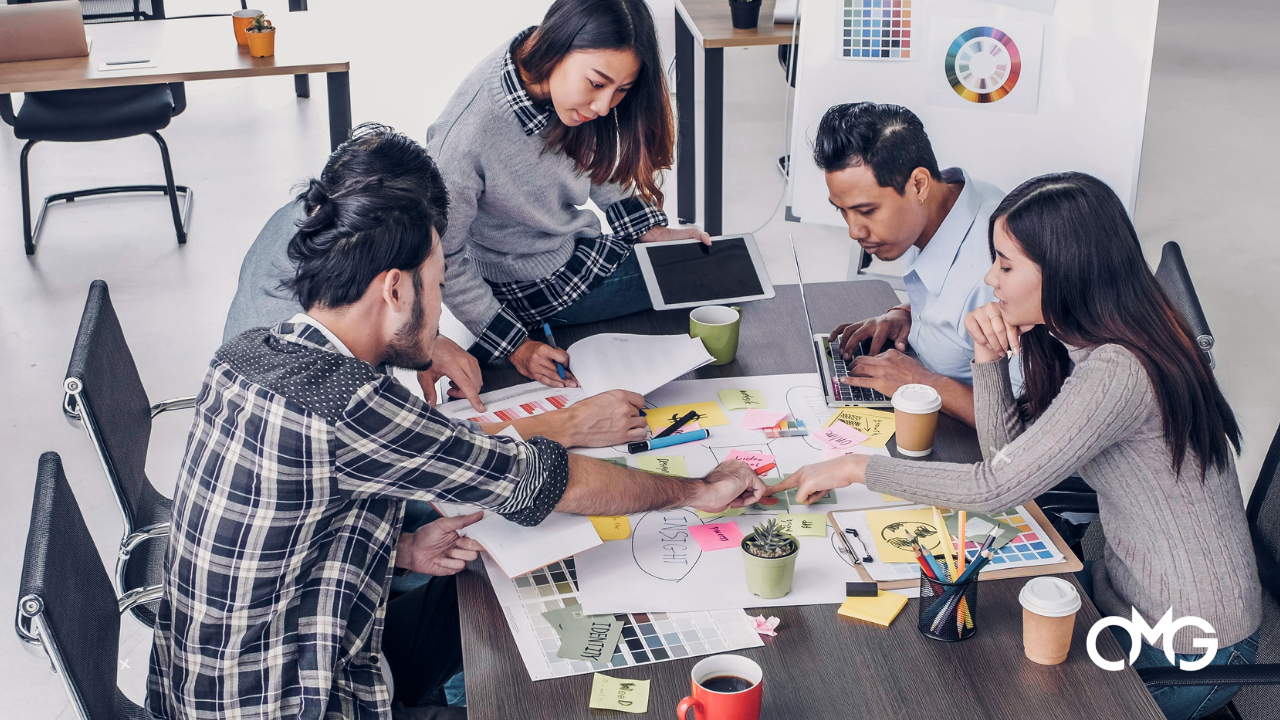 A group of people are sitting around a table having a meeting.