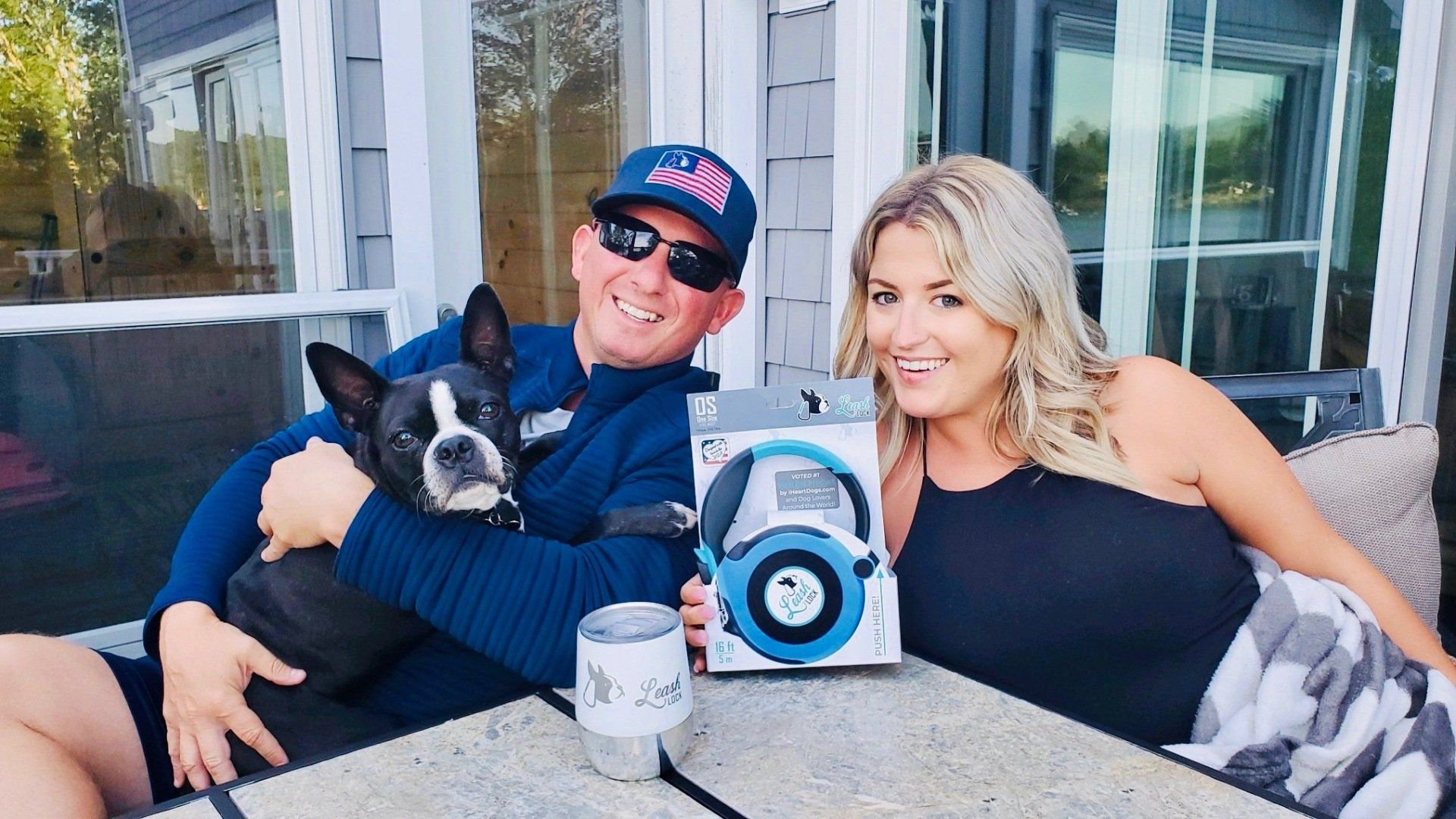 A man and a woman are sitting at a table with a dog and headphones.