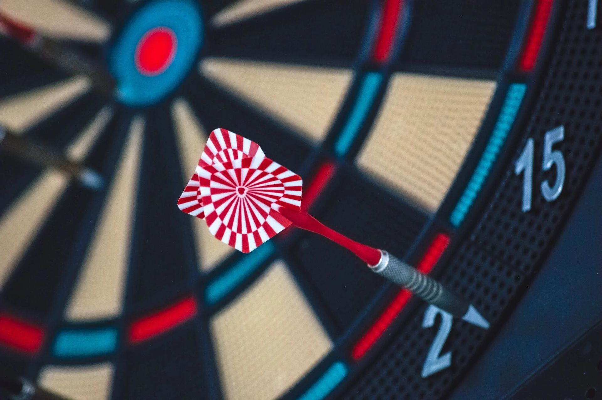 A close-up of a red dart in a dart board.