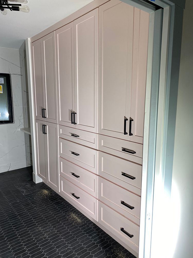 Floor to ceiling white cabinets with black handles