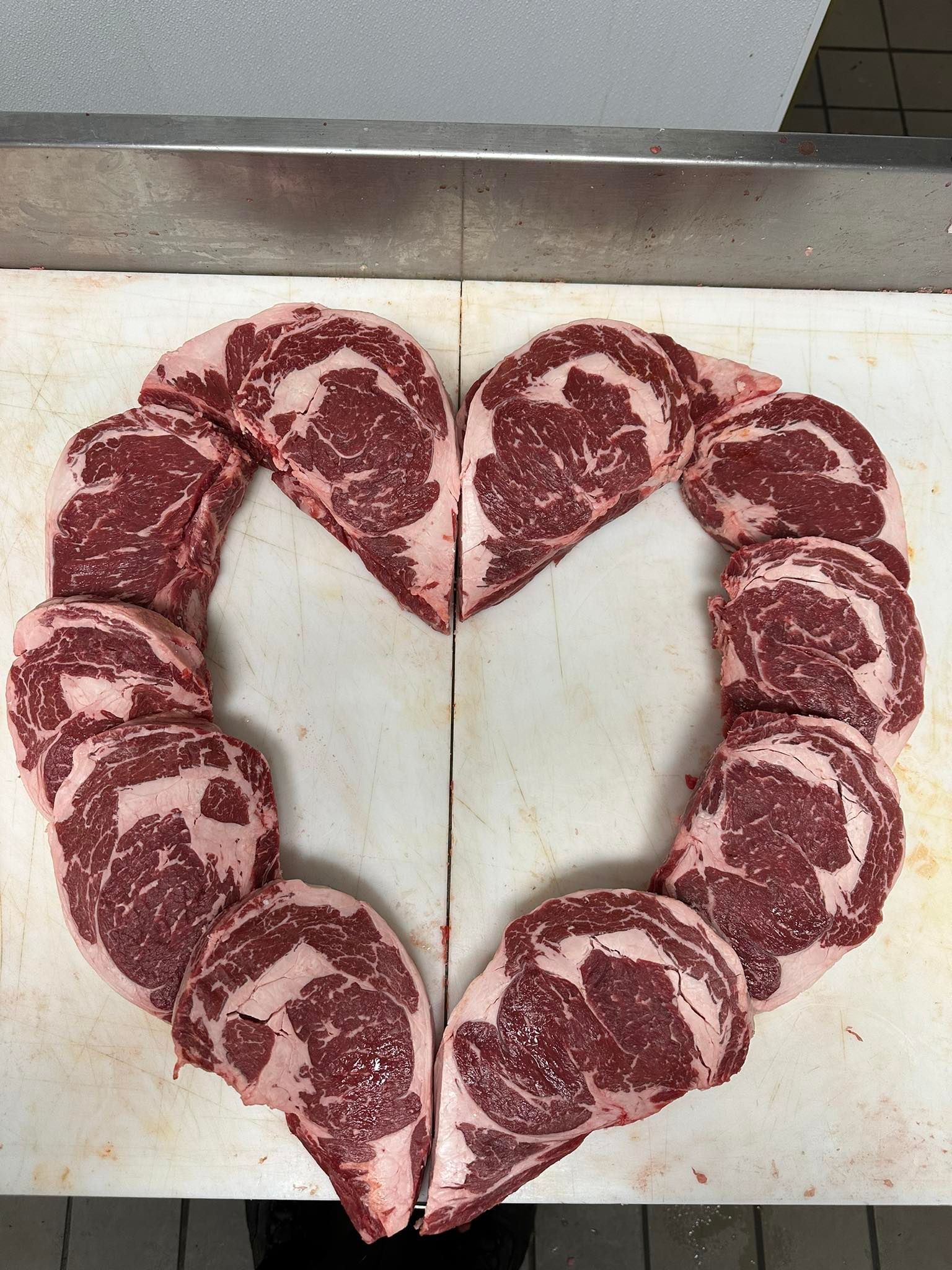 Raw steak slices arranged in a heart shape on a cutting board