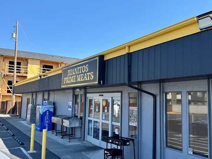 Giantos Paneras storefront with blue-and-yellow awning, glass doors, and outdoor benches on a sunny day