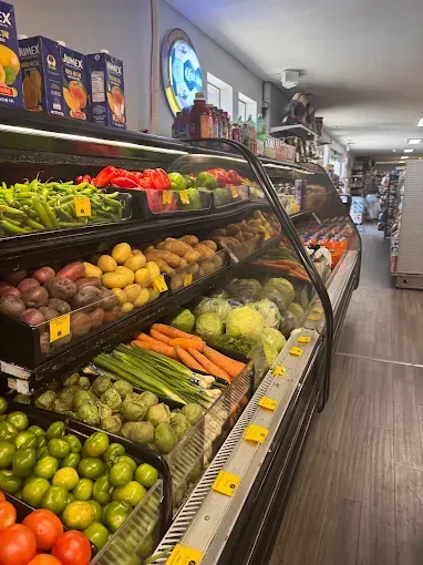 Produce aisle with neatly stacked fresh fruits and vegetables in a grocery store.