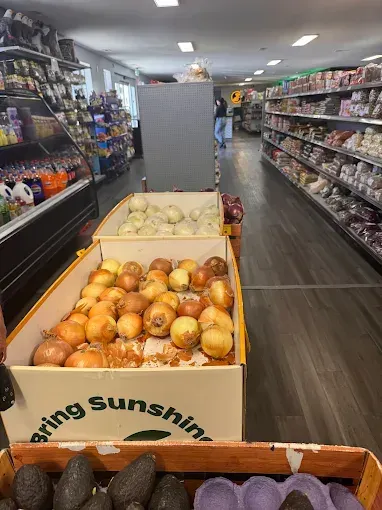 Grocery store aisle with produce boxes of onions and citrus on display