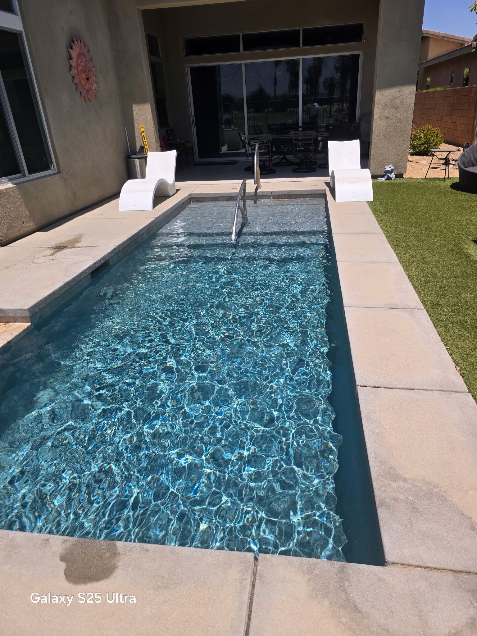 A large swimming pool in the backyard of a house.