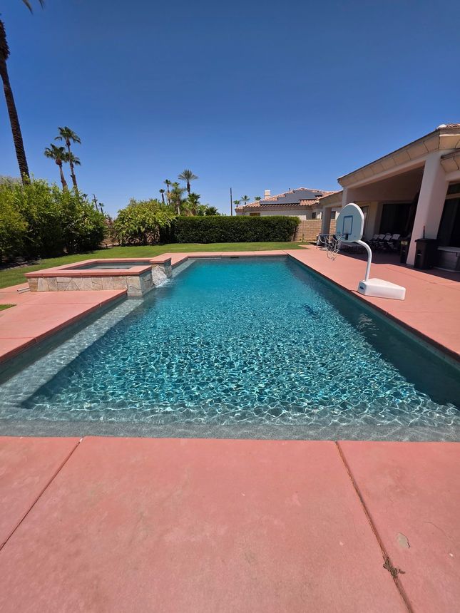 A large swimming pool with a wooden fence surrounding it.