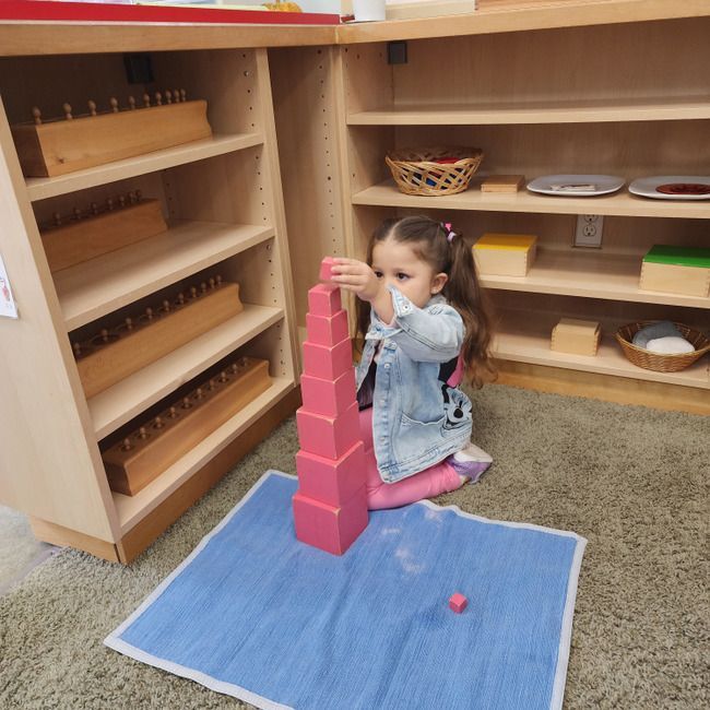 Montessori child building pink tower