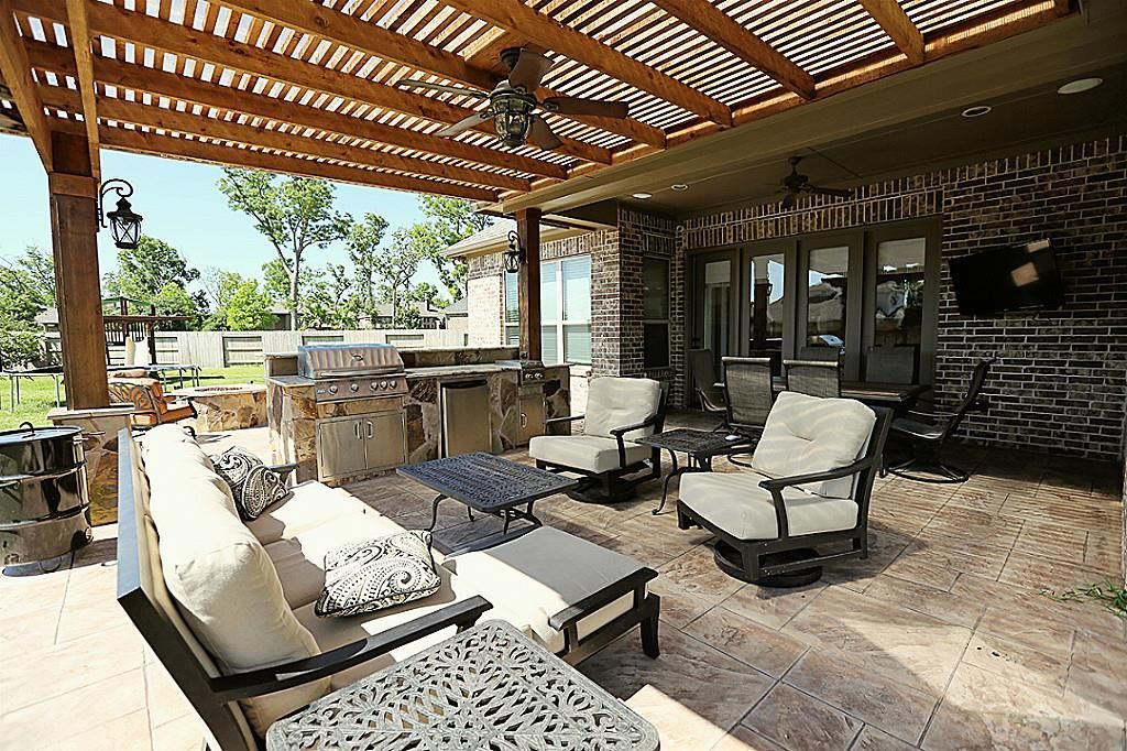 Patio cover in Austin TX with ceiling fans & stone columns.
