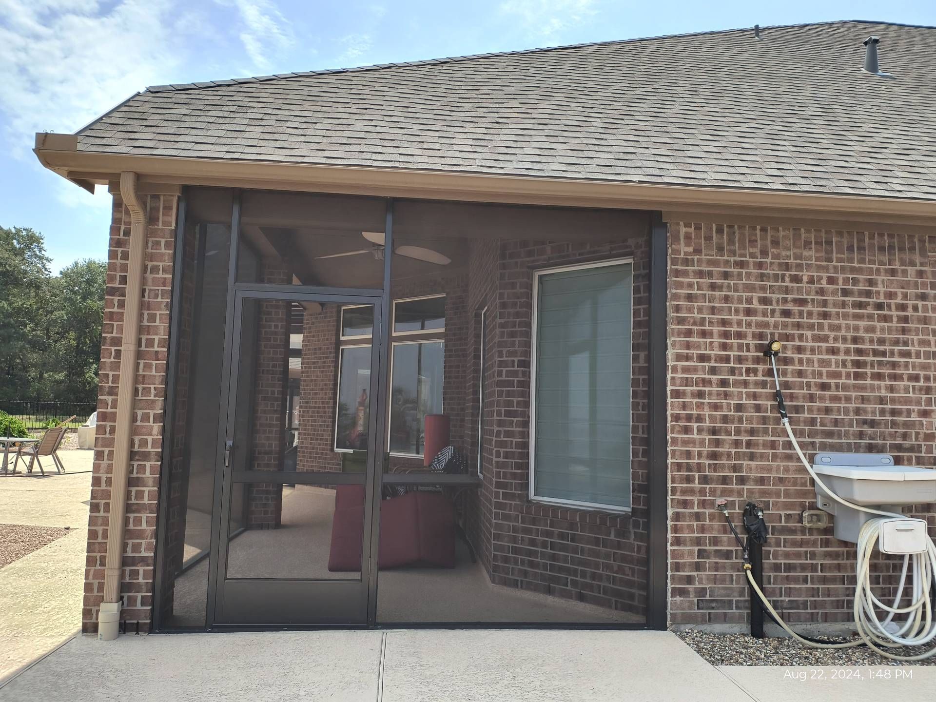 Garden Ridge screen room built with heavy‑duty framing and a wide overhang to increase shade coverage.